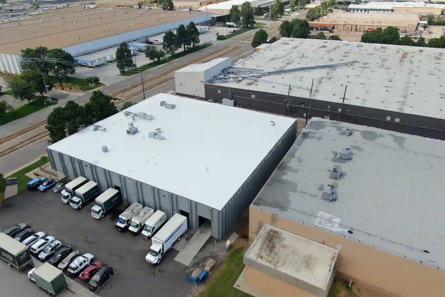 Aerial view of a white commercial TPO roof on an industrial warehouse building in Colorado