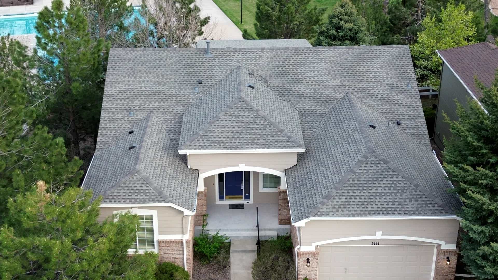 Aerial drone view of a completed architectural asphalt shingle roof replacement on a home in Castle Rock, Colorado