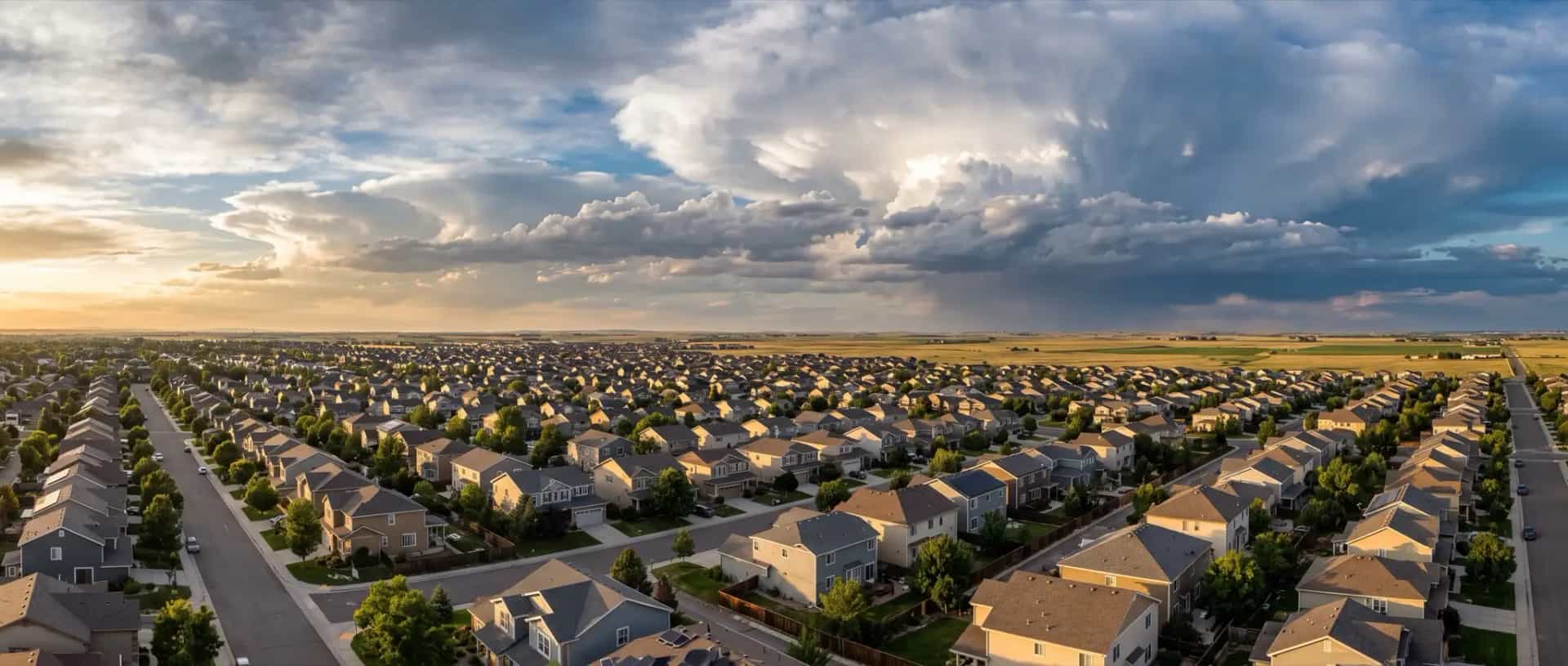 Illustrative representation of suburban rooftops on the eastern Denver metro plains near Aurora, Colorado, under a building storm sky