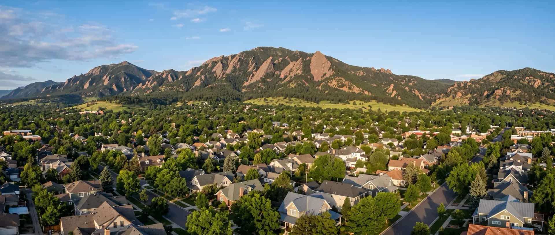 Illustrative representation of residential rooftops in Boulder, Colorado beneath the tilted sandstone slabs of the Flatirons