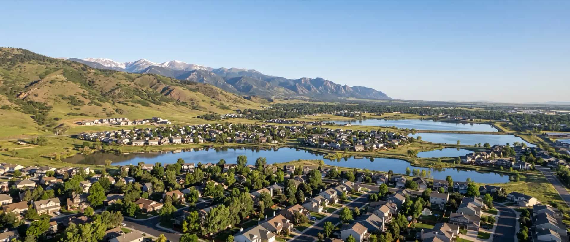 Illustrative representation of rooftops among the lakes of Loveland, Colorado with the foothills rising immediately to the west