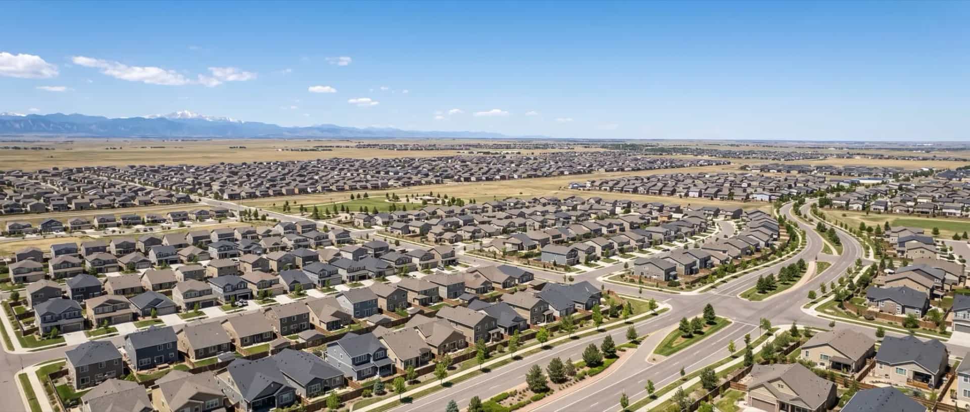 Illustrative representation of dense rows of newer suburban rooftops on flat terrain in Thornton, Colorado