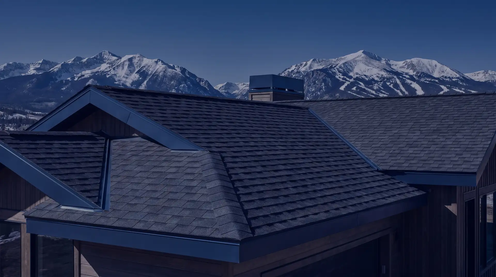 Architectural shingle roof against the snow-capped Colorado Rocky Mountains