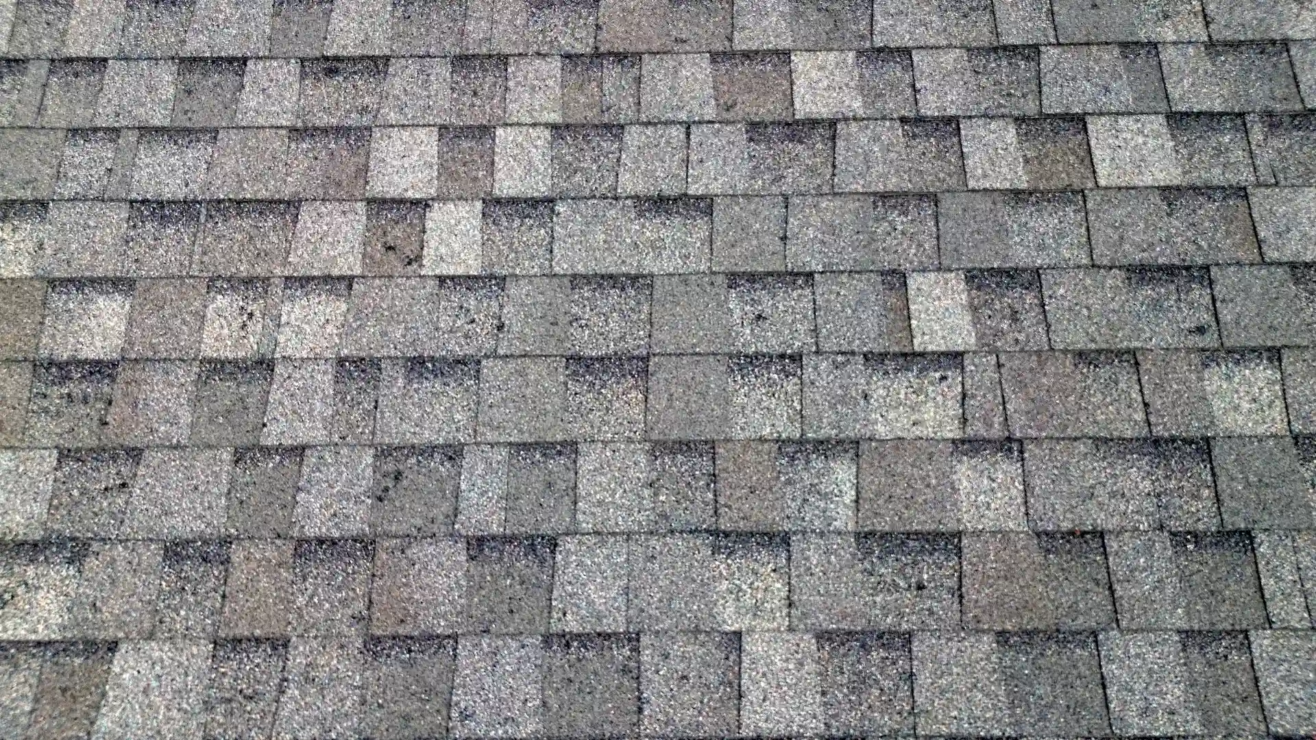 Close-up of new architectural asphalt shingles in a weathered-wood gray blend on a home in Colorado Springs, Colorado