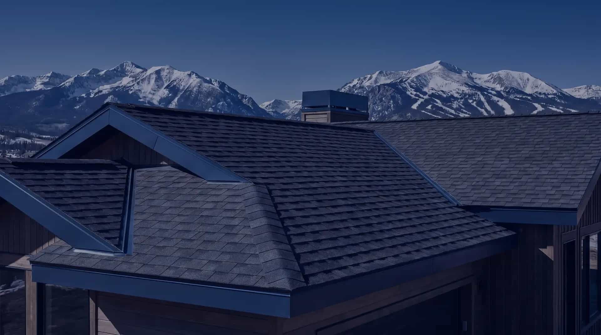 Architectural shingle roof against the snow-capped Colorado Rocky Mountains