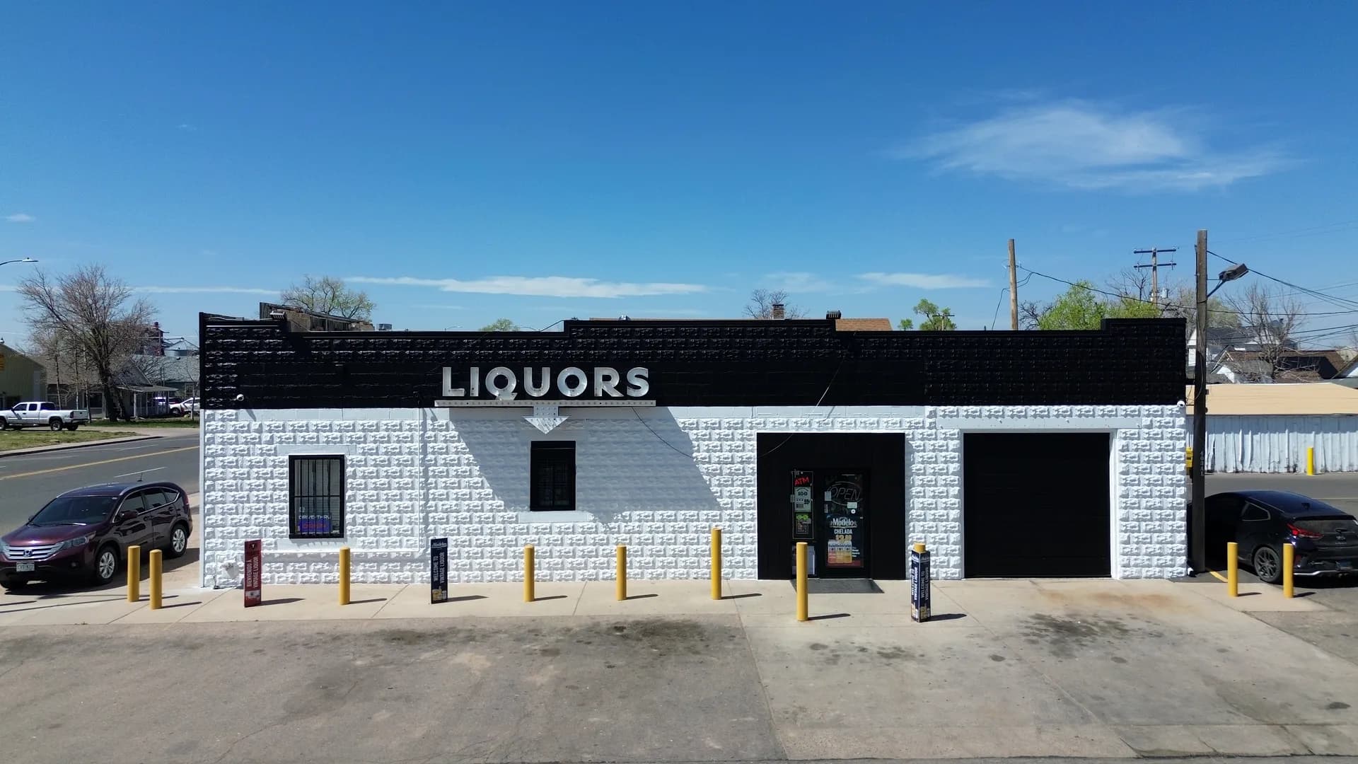 Street view of the black and white Vintage Liquor storefront with its dimensional LIQUORS sign in Greeley, Colorado
