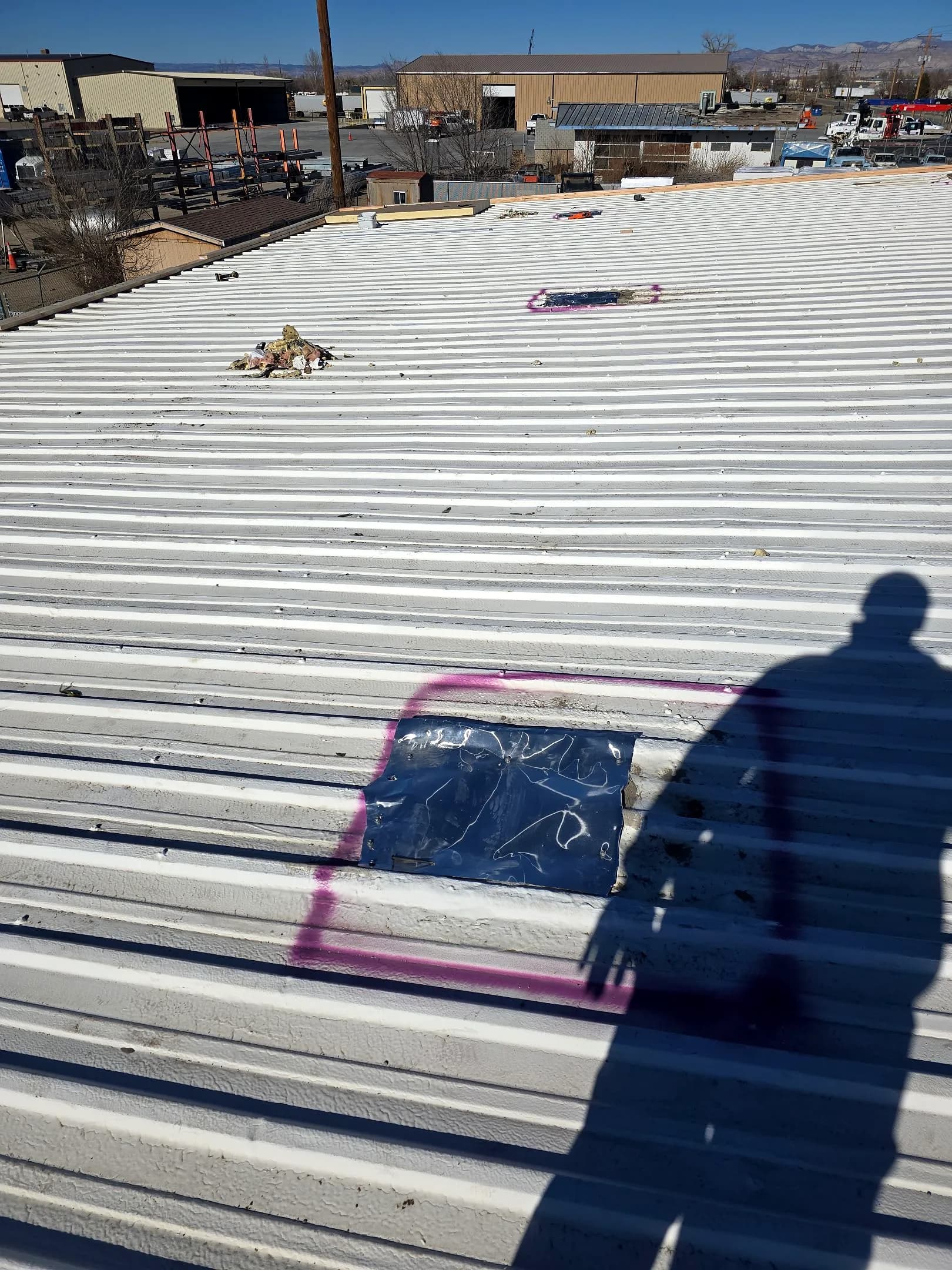 Close-up of an aging ribbed metal commercial roof in Grand Junction, Colorado showing weathered seams before replacement