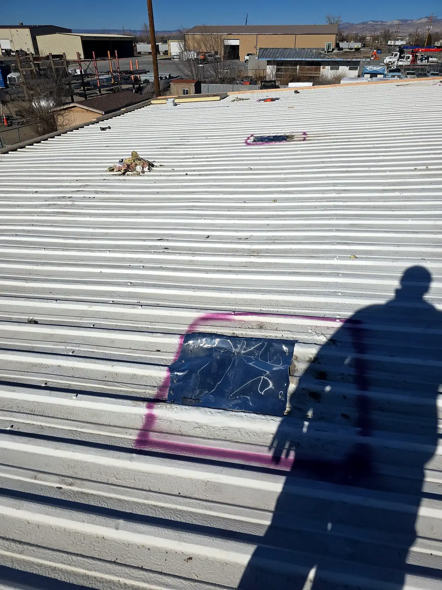 Close-up of an aging ribbed metal commercial roof in Grand Junction, Colorado showing weathered seams before replacement