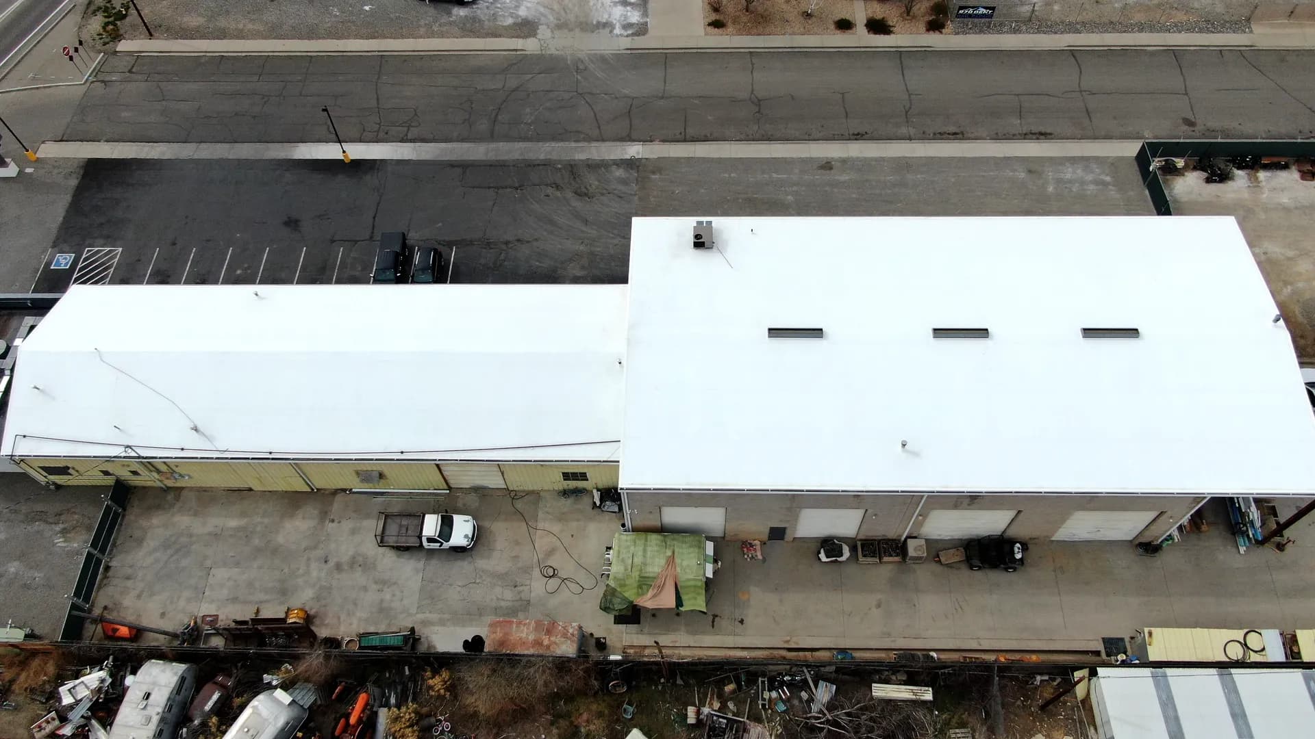 Top-down aerial view of the completed white membrane recover roof covering the full footprint of a commercial metal building in Grand Junction, Colorado