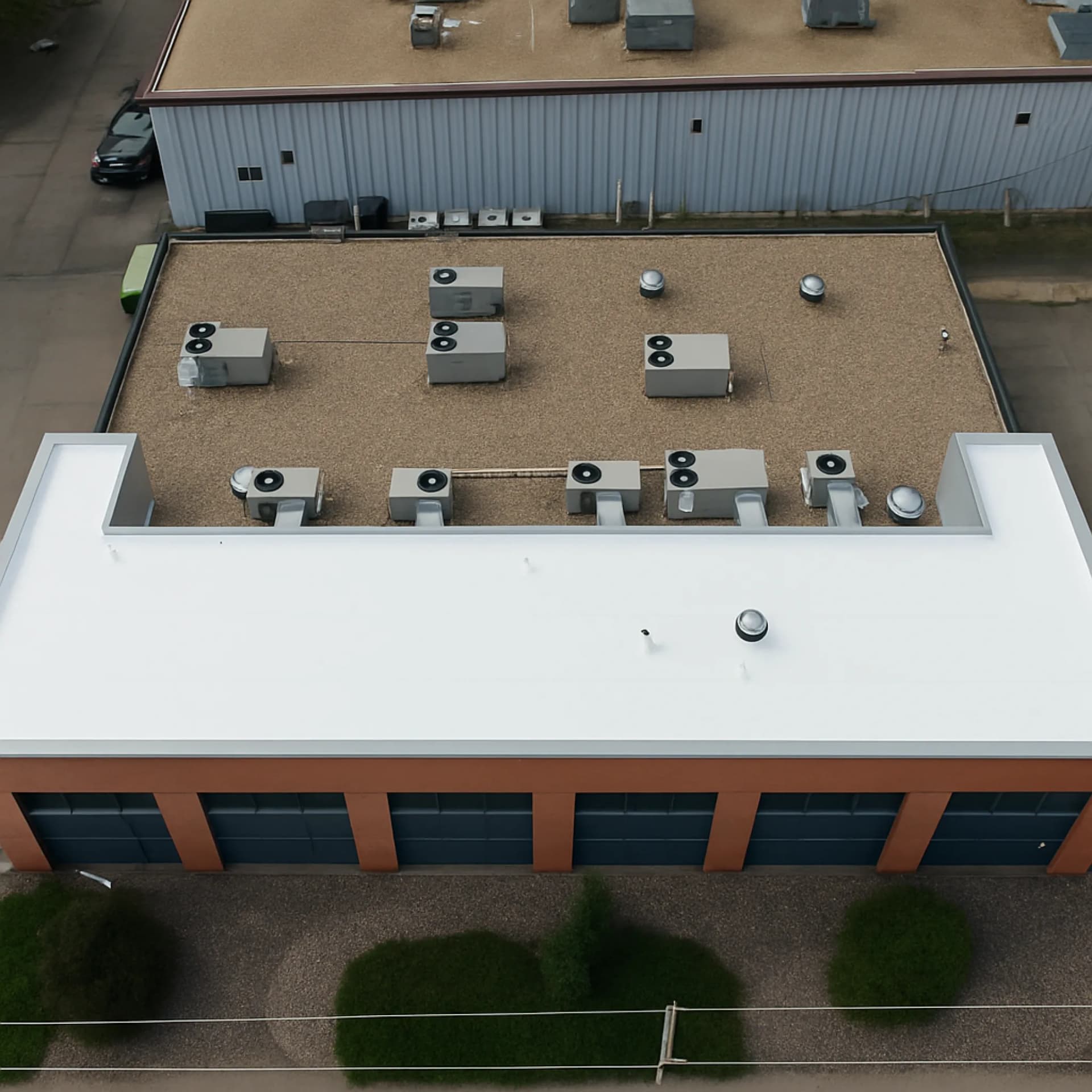 Aerial view of the completed white TPO roof on the smaller office building in the Northfield area of Denver, Colorado
