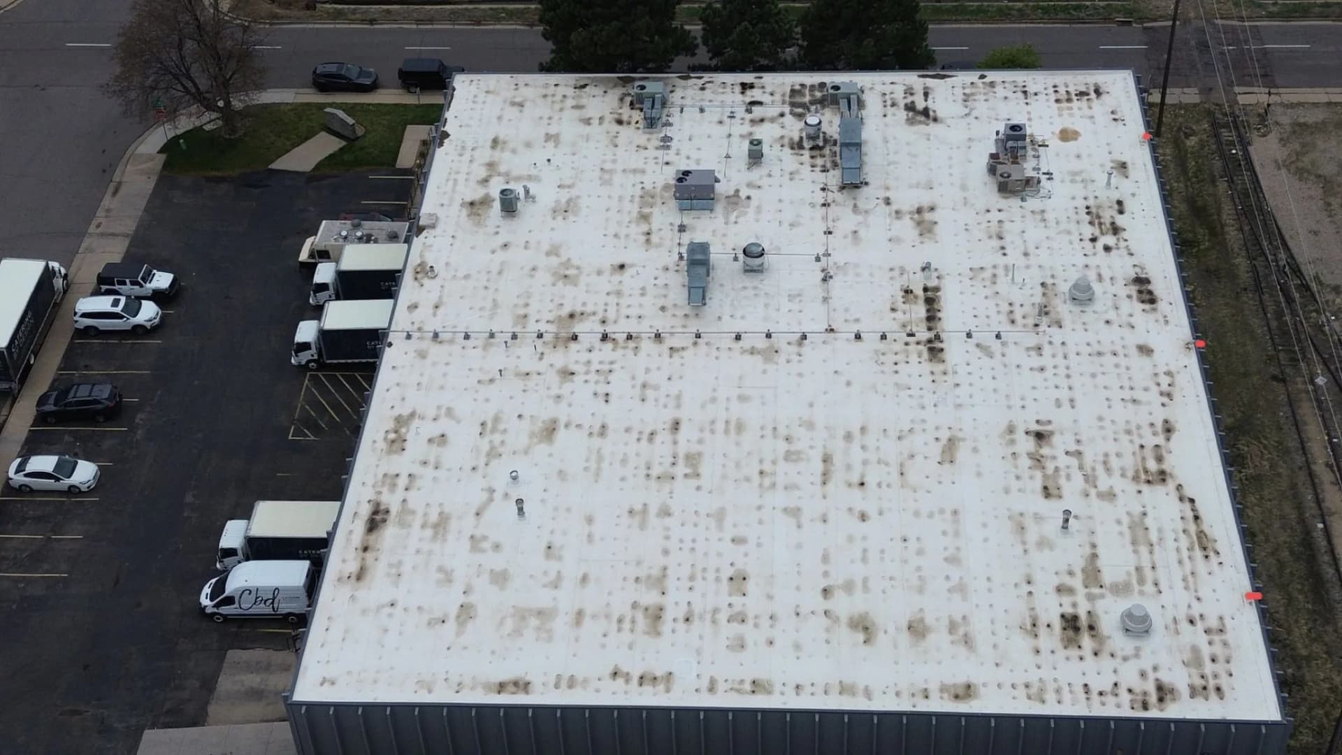Aerial view of an aged, hail-worn low-slope commercial roof in the Northfield area of Denver, Colorado before a TPO replacement
