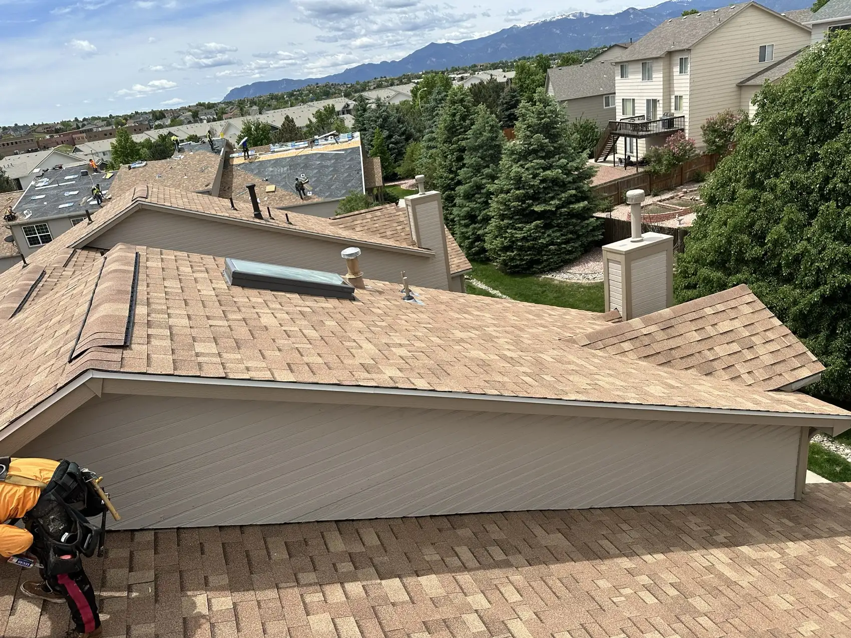 Completed Malarkey Vista AR shingle roof on a condominium building in Colorado Springs, Colorado, with the Front Range and Pikes Peak in the background