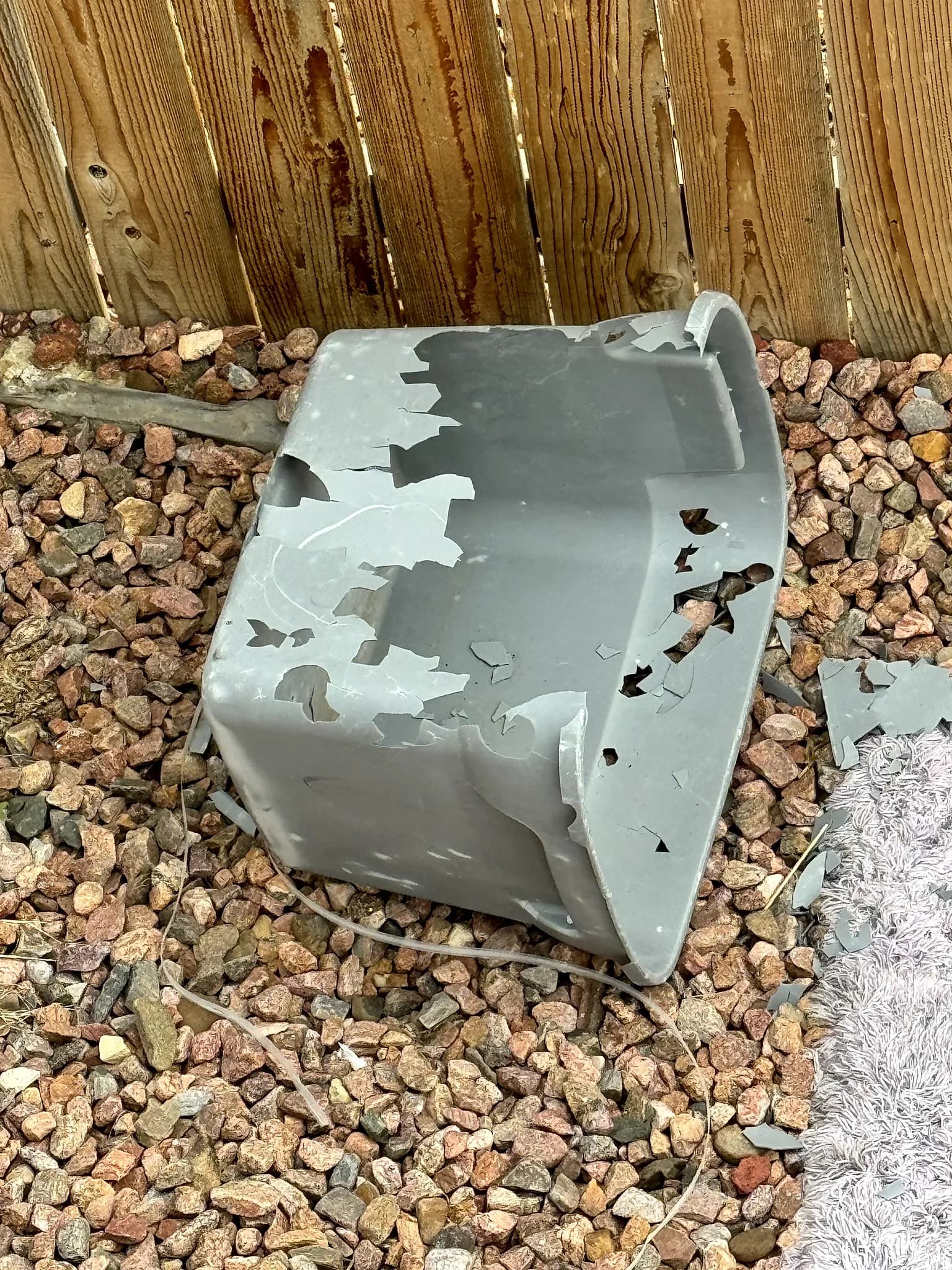Hail dents in a metal downspout on a home in Colorado Springs, evidence of a hailstorm's severity