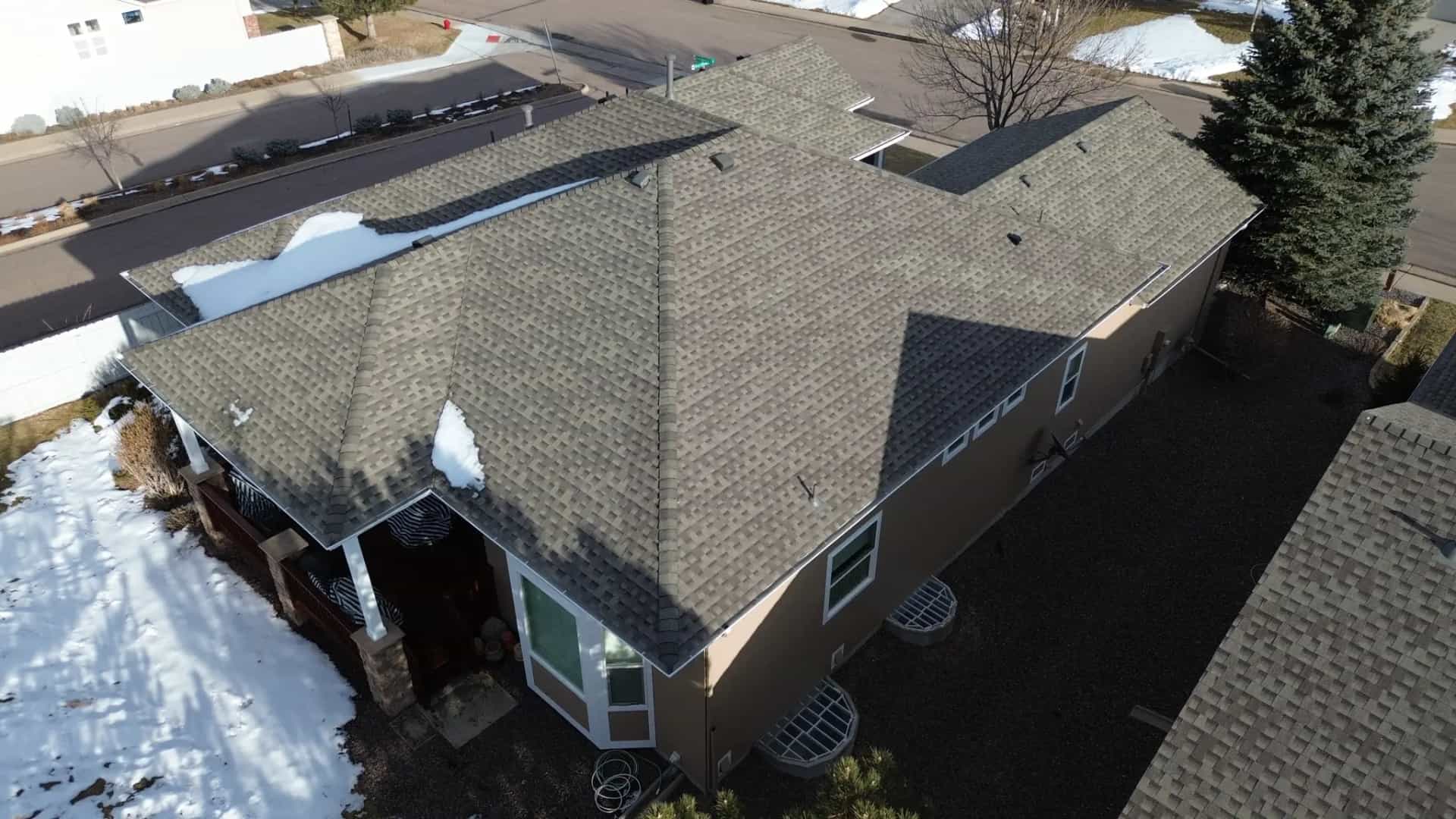 Aerial view of a completed Class 4 shingle roof on a home in Castle Pines, Colorado, surrounded by ponderosa pines