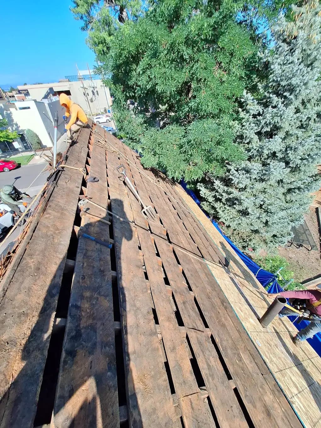 CRC crew installing new OSB roof decking over exposed spaced boards on a steep roof in Cherry Creek North, Denver, Colorado