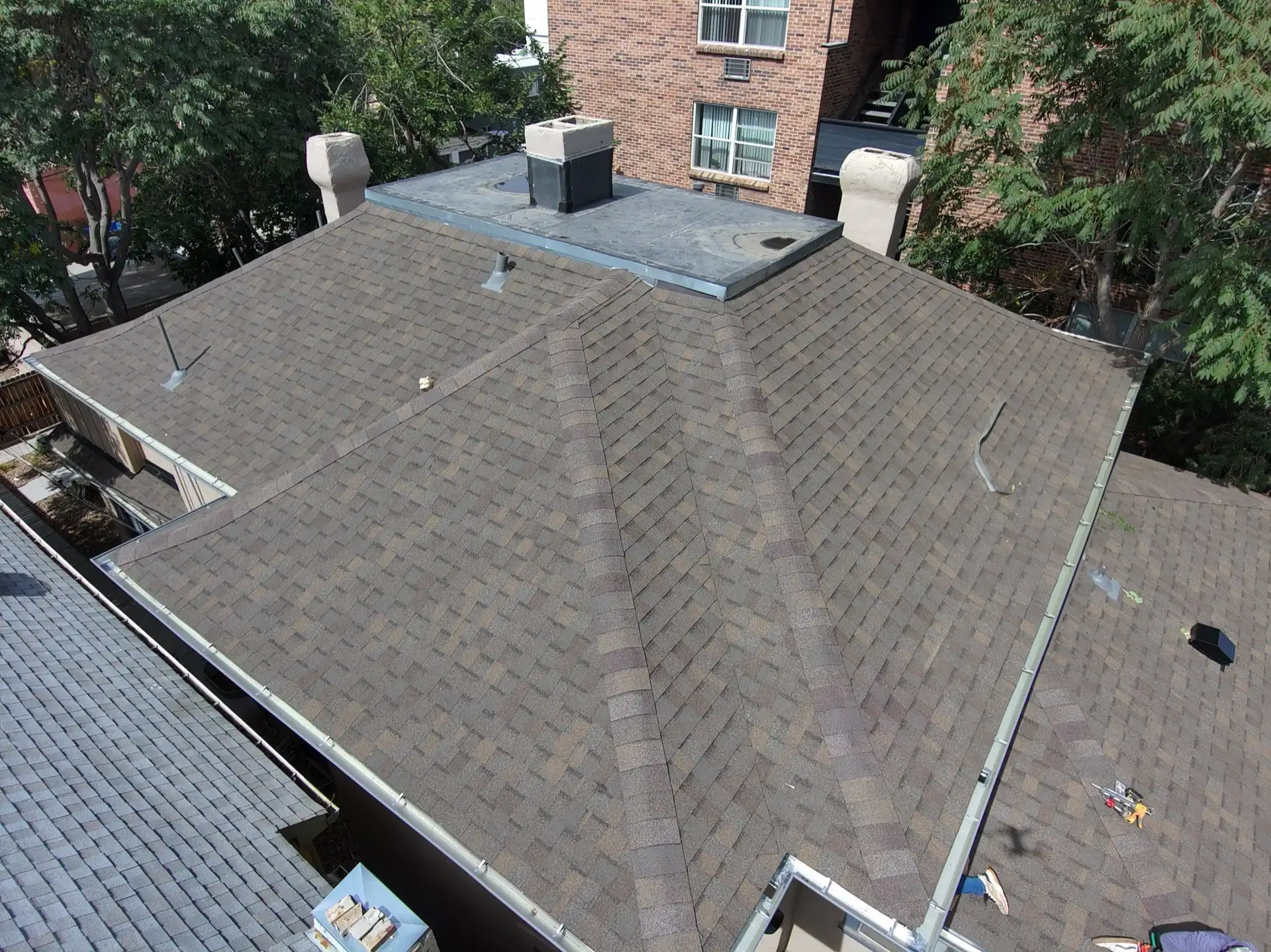 Aerial view of a completed brown architectural shingle roof with hip and valley framing on a home in Denver, Colorado, after a hail insurance reroof