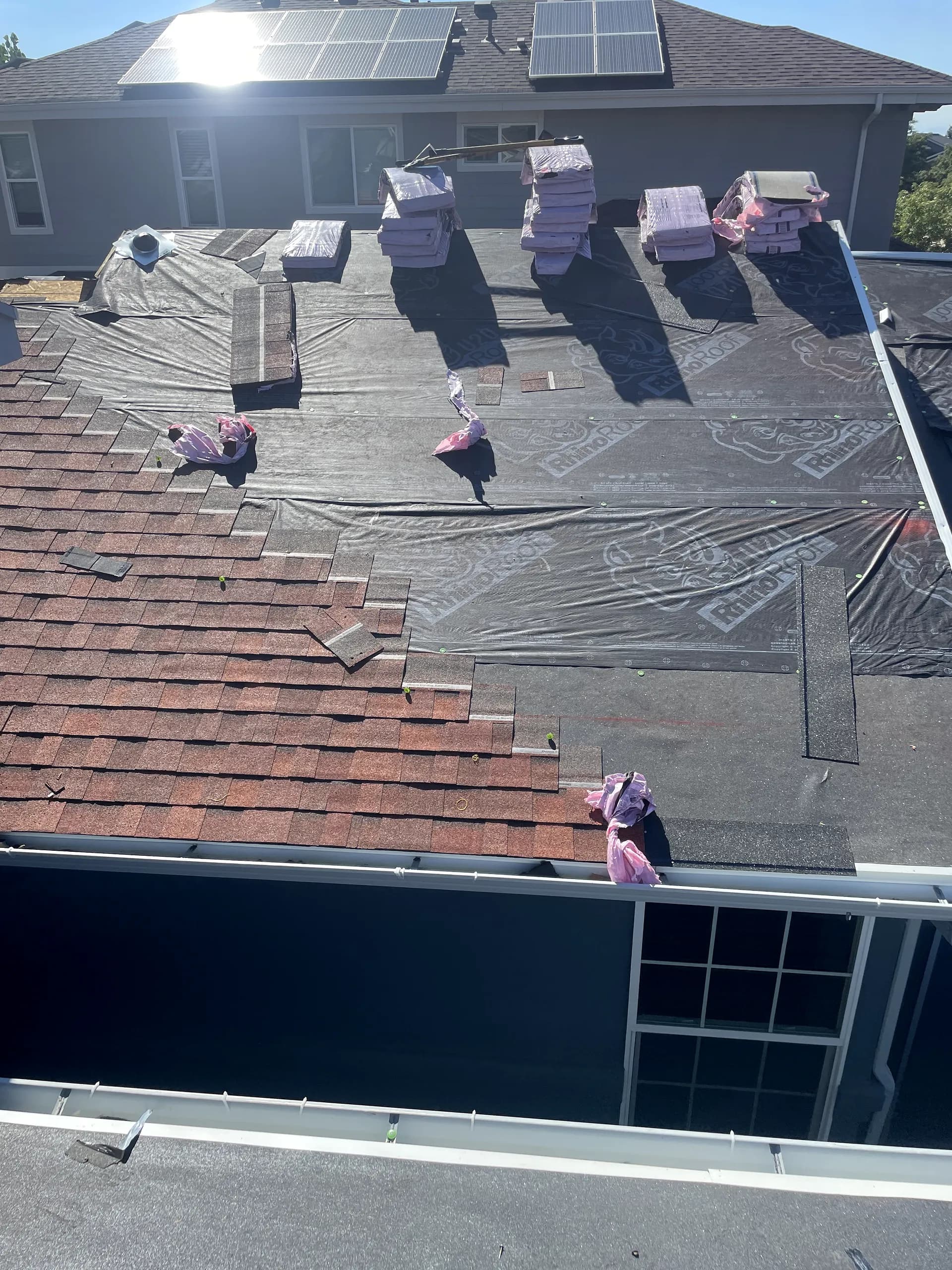 Asphalt shingle roof tear-off in progress on a home in Aurora, Colorado, Owens Corning Duration shingles staged for install