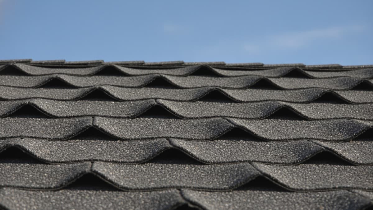 Illustrative representation of asphalt shingles curling and cupping at the edges from age and sun exposure